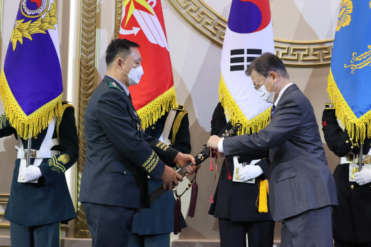 20일 문재인 대통령이 청와대 영빈관에서 열린 장성 진급·보직 신고 및 수치 수여식에서 여운태 8군단장의 삼정검에 수치를 달아주고 있다. 연합뉴스.